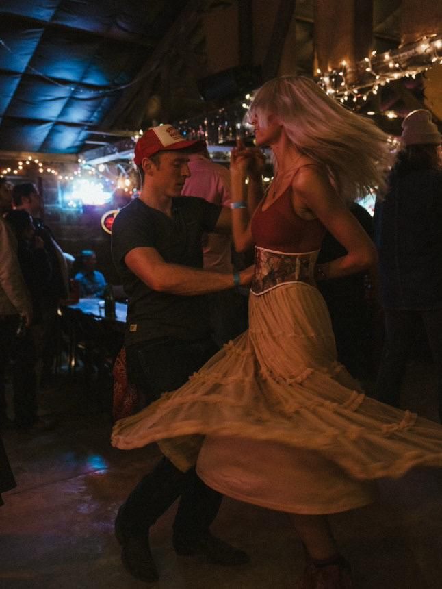 Couple dancing at a honky tonk under string lights